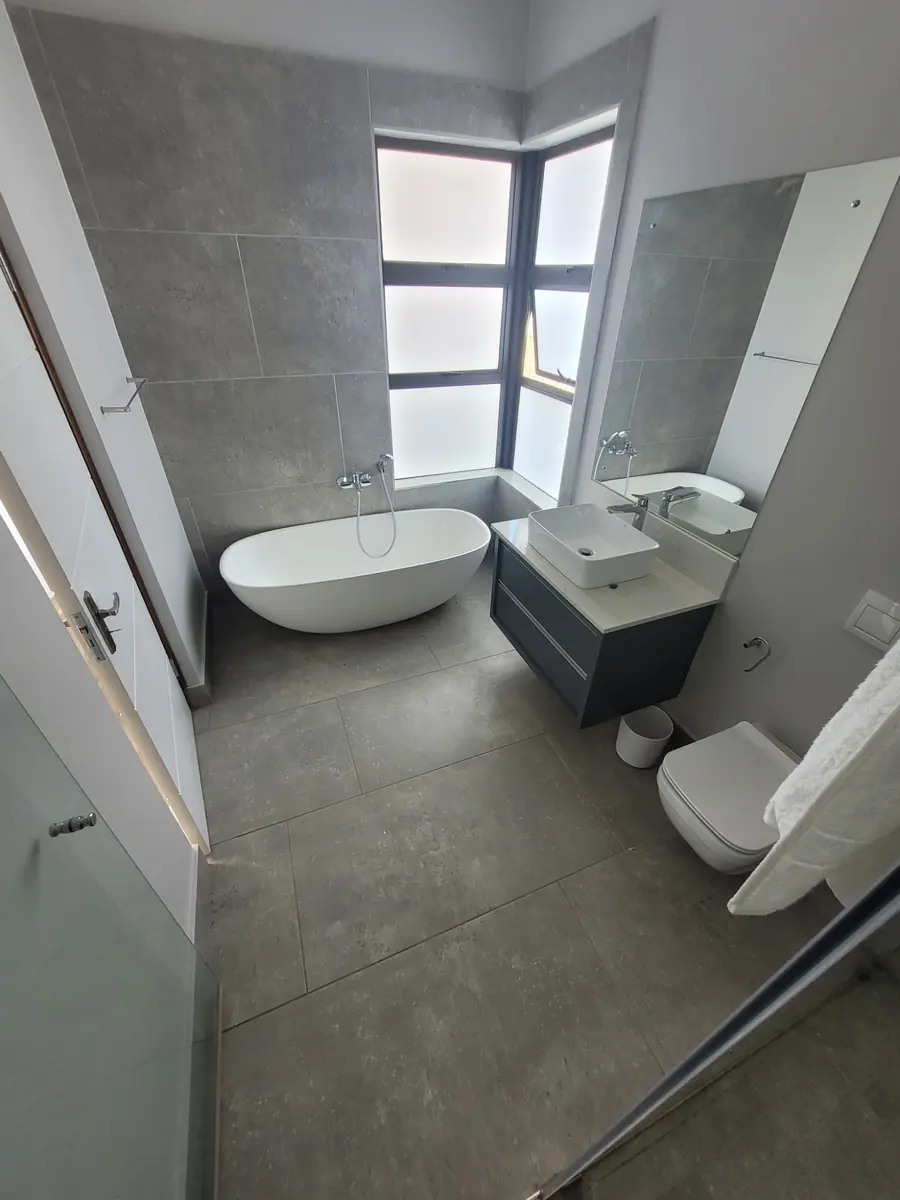 Completed grey bathroom with freestanding bath and floating vanity